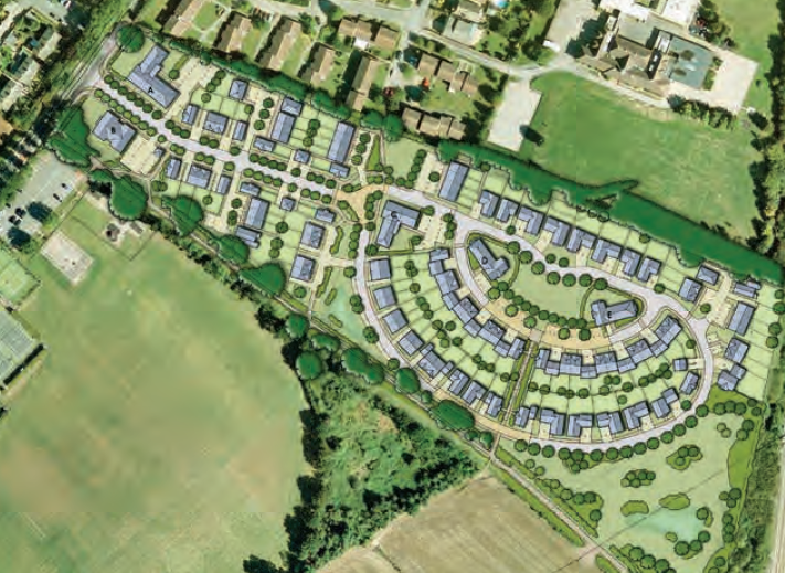 Aerial view of curved residential housing estate with grey rooftops arranged in semi-circular pattern, surrounded by green fields and trees.